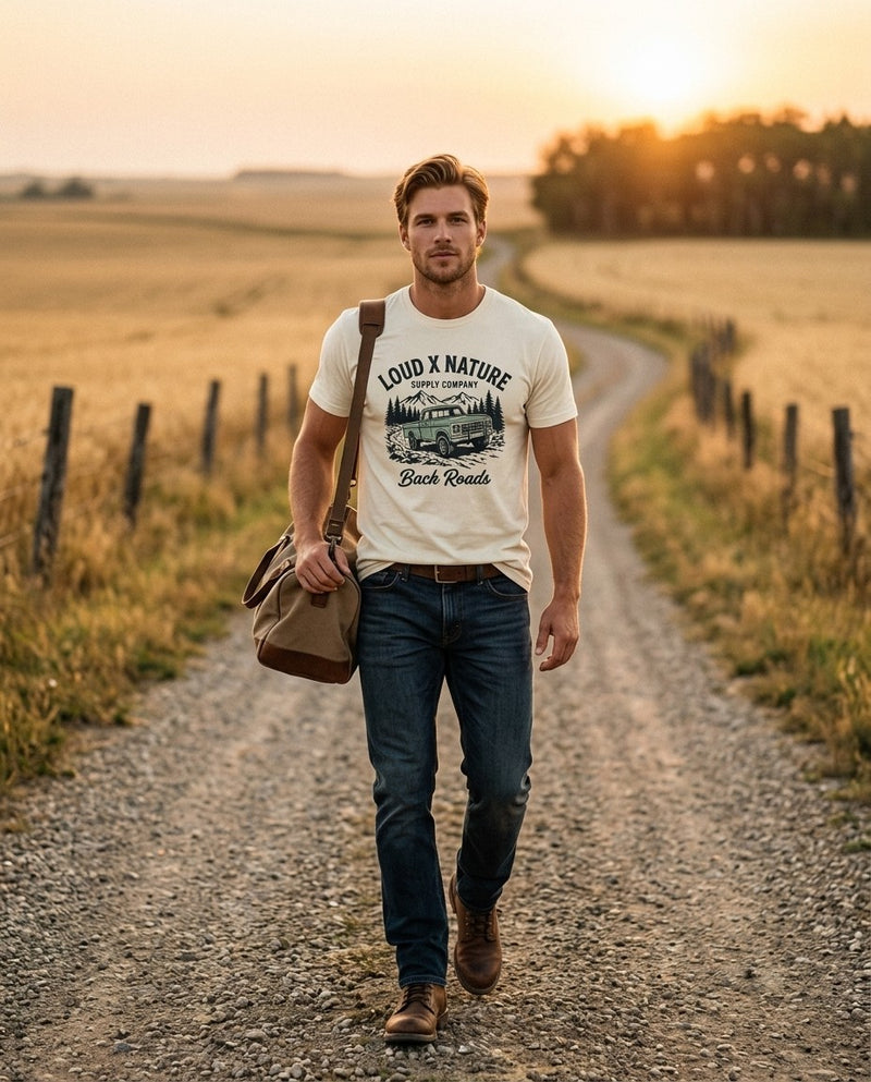 Back Roads tee on a gravel prairie road at sunset